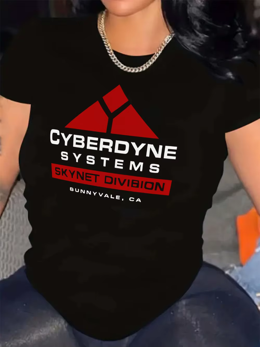 Le t-shirt noir présente un graphique du système Cybernet rouge et blanc avec un motif triangulaire 